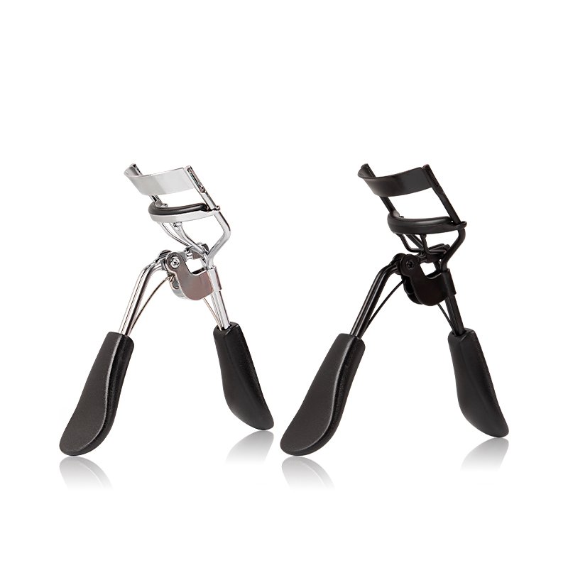 SANGAM Eyelash Curler in black and silver showing steel bracket, ergonomic handle, and non-slip rubber mat. Title: